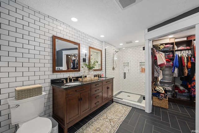 2107 W 450 S, Lafayette, IN 47909 - full bath featuring double vanity, tile walls, a walk in closet, a stall shower, and a textured ceiling