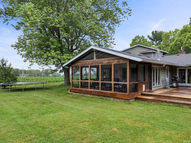 2107 W 450 S, Lafayette, IN 47909 - back of house with a trampoline, a sunroom, a deck, a yard, and roof with shingles