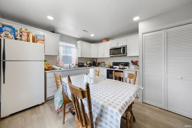 3420 Mccormick Ave, Fort Wayne, IN 46803 - kitchen with white appliances, light wood-type flooring, light countertops, decorative backsplash, and recessed lighting