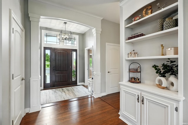 3908 County Road 4, Ashley, IN 46705 - foyer featuring dark wood-style flooring, ornate columns, a chandelier, and crown molding