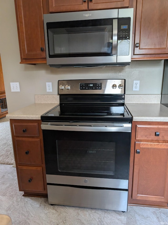 117 Blue Heron Cv, Decatur, IN 46733 - kitchen featuring appliances with stainless steel finishes, light countertops, and brown cabinetry