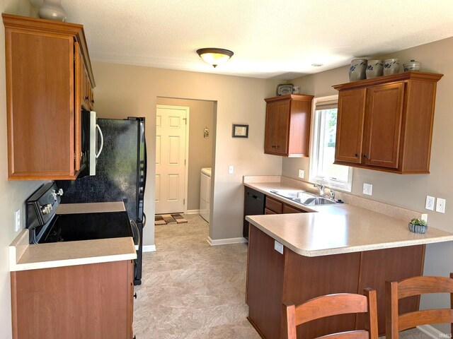 117 Blue Heron Cv, Decatur, IN 46733 - kitchen featuring a peninsula, separate washer and dryer, stainless steel microwave, light countertops, and a breakfast bar