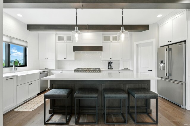 13176 Malfini Trl, Fort Wayne, IN 46845 - kitchen with stainless steel appliances, a breakfast bar area, light wood-style floors, light countertops, and backsplash