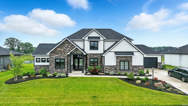 13176 Malfini Trl, Fort Wayne, IN 46845 - view of front facade featuring board and batten siding, driveway, a front yard, and stone siding