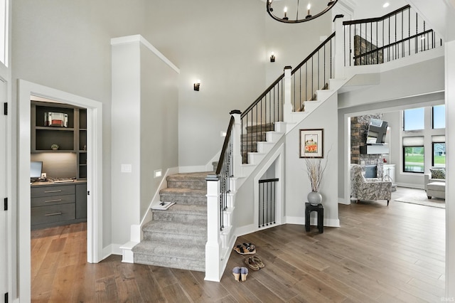 13176 Malfini Trl, Fort Wayne, IN 46845 - stairs featuring a towering ceiling, wood finished floors, and a chandelier