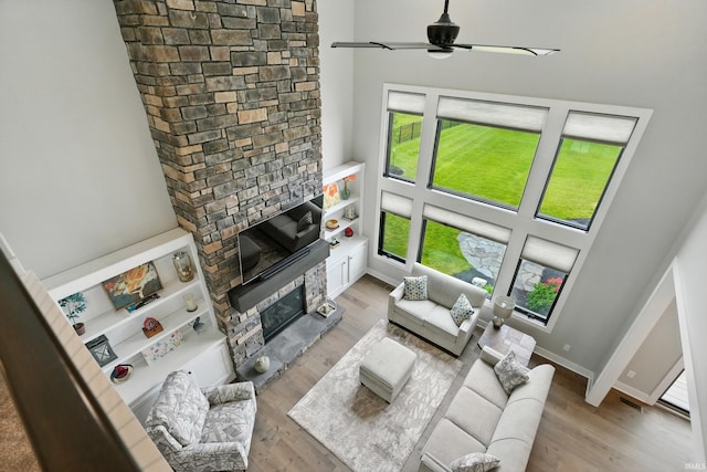 13176 Malfini Trl, Fort Wayne, IN 46845 - living area with a stone fireplace, light wood-style floors, and ceiling fan