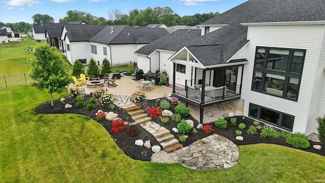 13176 Malfini Trl, Fort Wayne, IN 46845 - back of house featuring an outdoor fire pit, a shingled roof, a residential view, and a patio