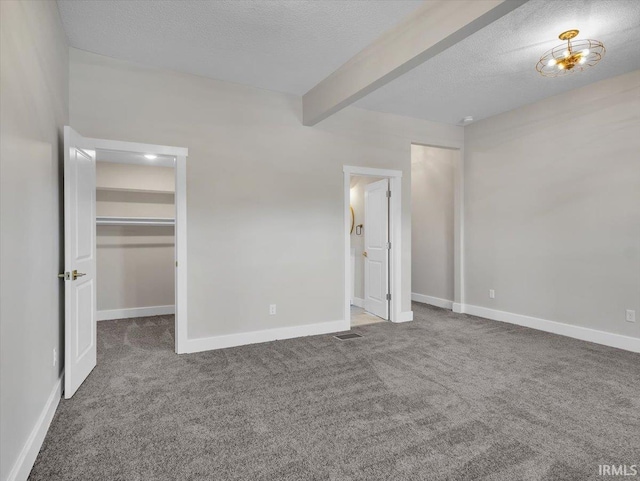 439 E Wayne St, Fort Wayne, IN 46802 - unfurnished bedroom featuring beam ceiling, carpet flooring, a textured ceiling, and a spacious closet