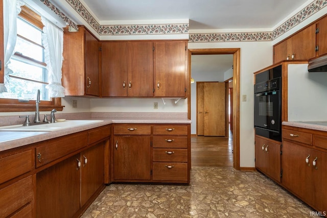 644 W Ladd Ave, Bloomington, IN 47403 - kitchen with oven, brown cabinetry, light countertops, light flooring, and under cabinet range hood