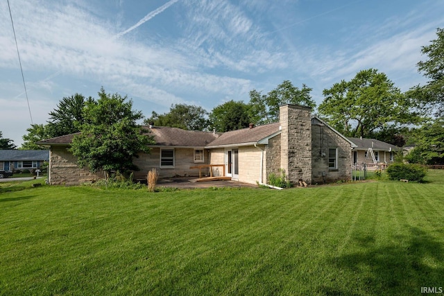 644 W Ladd Ave, Bloomington, IN 47403 - back of house with stone siding, a lawn, a chimney, and a patio area