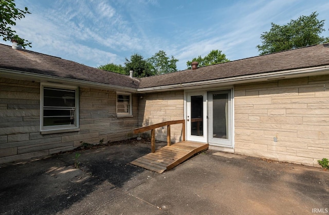 644 W Ladd Ave, Bloomington, IN 47403 - view of exterior entry with a patio, roof with shingles, and stone siding