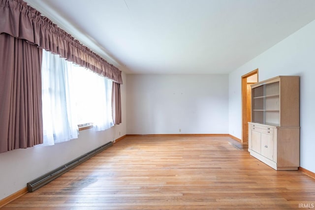 644 W Ladd Ave, Bloomington, IN 47403 - empty room with a baseboard heating unit and light wood-type flooring