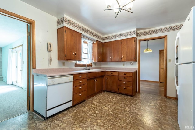 644 W Ladd Ave, Bloomington, IN 47403 - kitchen featuring white appliances, brown cabinets, light countertops, and a chandelier