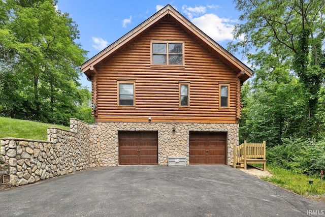 5818 Prophets Rock Rd, West Lafayette, IN 47906 - view of home's exterior with driveway, stone siding, log siding, and an attached garage