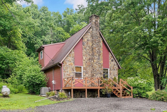 10154 W Rock E Rd, Bloomington, IN 47403 - view of front facade featuring stone siding, a wooden deck, and a chimney