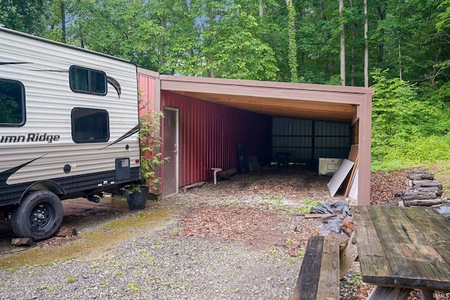 10154 W Rock E Rd, Bloomington, IN 47403 - garage featuring a carport and gravel driveway