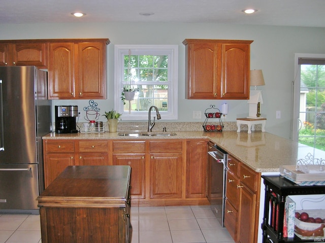 2622 Oak Trail Dr, Newburgh, IN 47630 - kitchen featuring appliances with stainless steel finishes, a peninsula, light stone counters, light tile patterned flooring, and recessed lighting