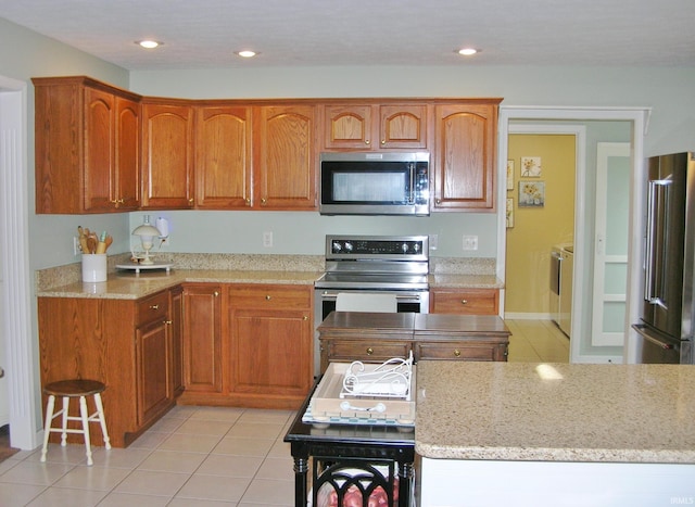 2622 Oak Trail Dr, Newburgh, IN 47630 - kitchen with appliances with stainless steel finishes, light tile patterned floors, light stone countertops, brown cabinets, and recessed lighting
