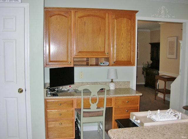 2622 Oak Trail Dr, Newburgh, IN 47630 - kitchen featuring built in desk, crown molding, light stone counters, and brown cabinets