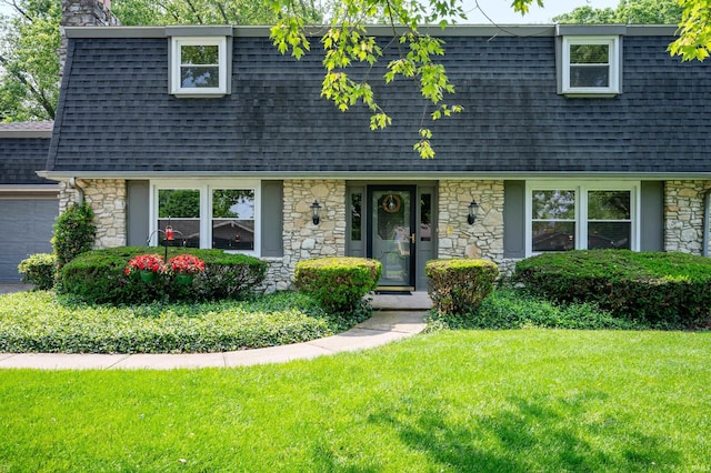 1105 N Buckeye Rd, Muncie, IN 47304 - view of front facade with roof with shingles, mansard roof, stone siding, and a garage