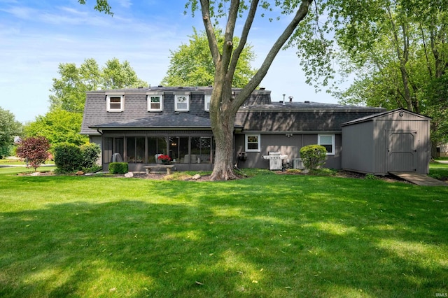 1105 N Buckeye Rd, Muncie, IN 47304 - back of house featuring a sunroom, a shed, a shingled roof, and a lawn