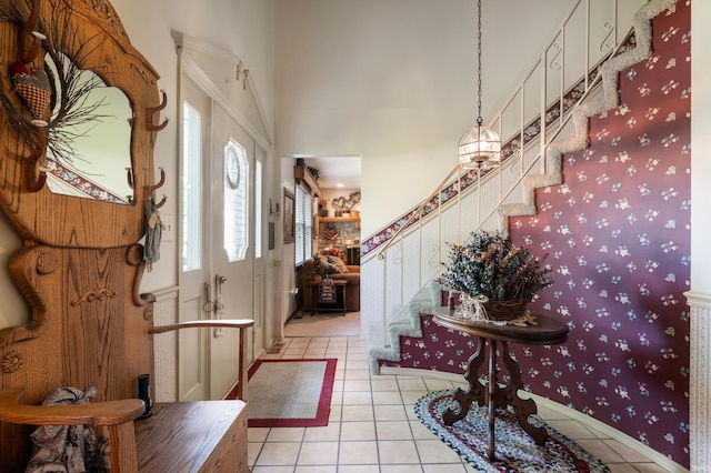 1105 N Buckeye Rd, Muncie, IN 47304 - entrance foyer featuring light tile patterned floors, stairs, a towering ceiling, and wallpapered walls