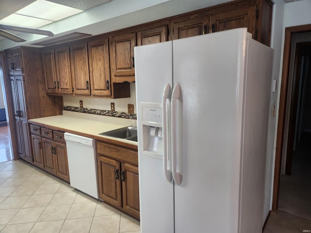 6480 E Mcguire Rd, Churubusco, IN 46723 - kitchen featuring white appliances, light tile patterned floors, light countertops, and brown cabinets