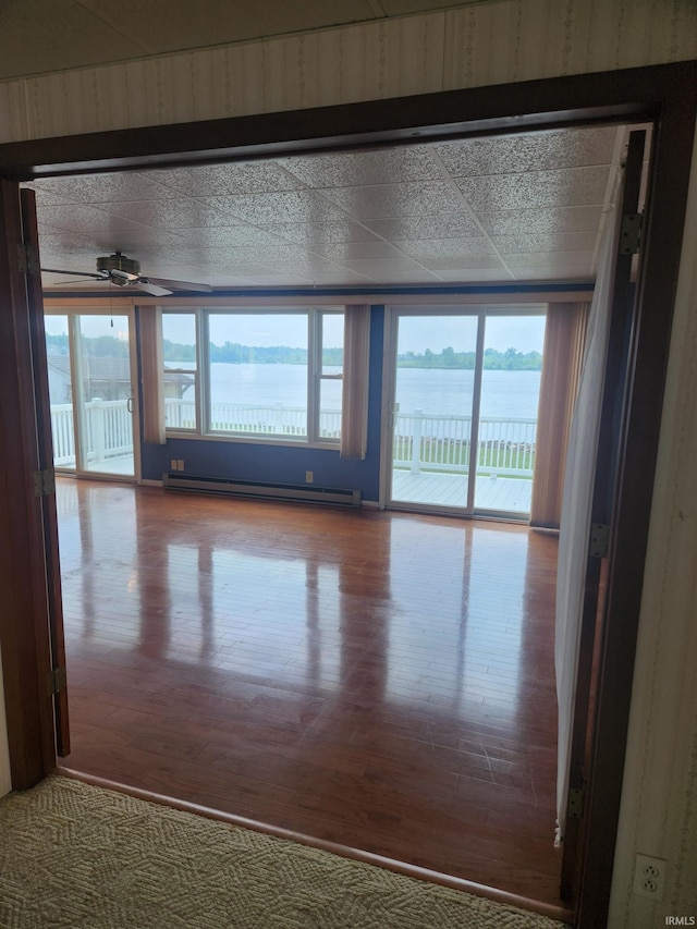 6480 E Mcguire Rd, Churubusco, IN 46723 - spare room featuring a baseboard heating unit, wood finished floors, and healthy amount of natural light