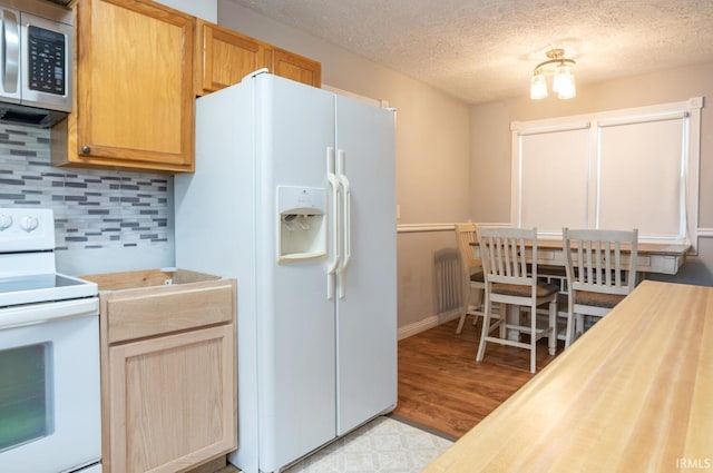 4260 W 3rd St, Bloomington, IN 47404 - kitchen with white appliances, decorative backsplash, light wood-type flooring, and a textured ceiling