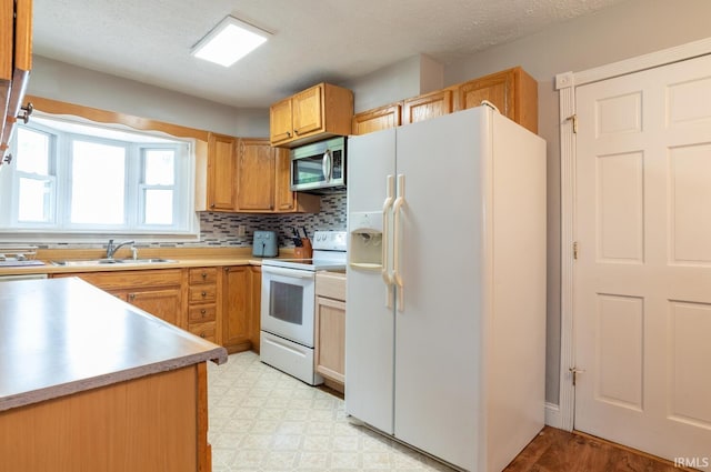 4260 W 3rd St, Bloomington, IN 47404 - kitchen featuring white appliances, light floors, light countertops, and backsplash