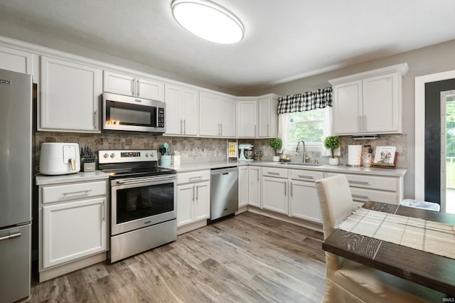 15880 N County Road 300 W, Gaston, IN 47342 - kitchen with stainless steel appliances, light wood-type flooring, tasteful backsplash, light countertops, and white cabinets