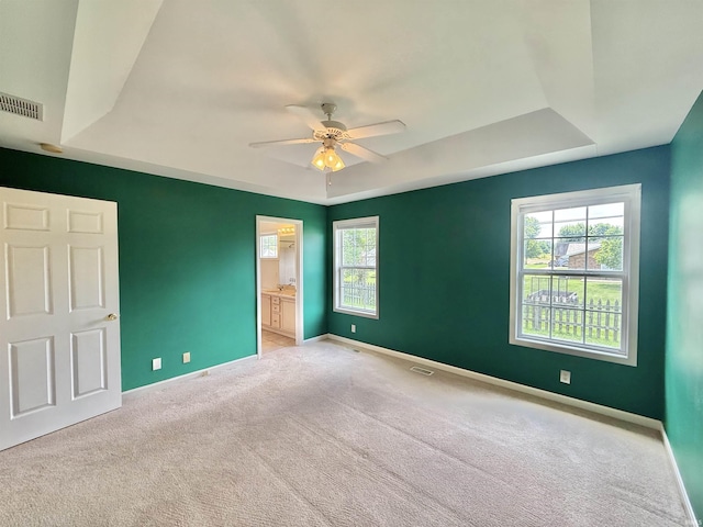 8433 Countrywood Ct, Newburgh, IN 47630 - unfurnished bedroom with a tray ceiling, carpet flooring, connected bathroom, and ceiling fan