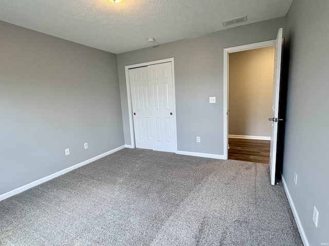 222 Sinclair Dr, West Lafayette, IN 47906 - unfurnished bedroom with dark colored carpet, a closet, and a textured ceiling