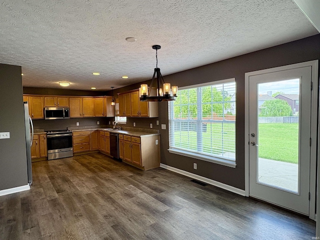 222 Sinclair Dr, West Lafayette, IN 47906 - kitchen with stainless steel appliances, a chandelier, dark wood-style flooring, a textured ceiling, and decorative light fixtures
