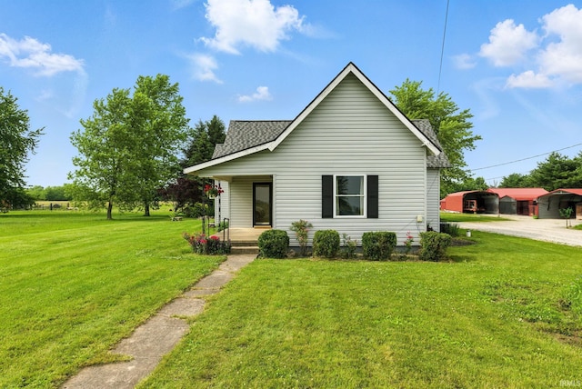 512 E Pike St, Kirklin, IN 46050 - bungalow-style house featuring a porch, a front lawn, roof with shingles, and dirt driveway