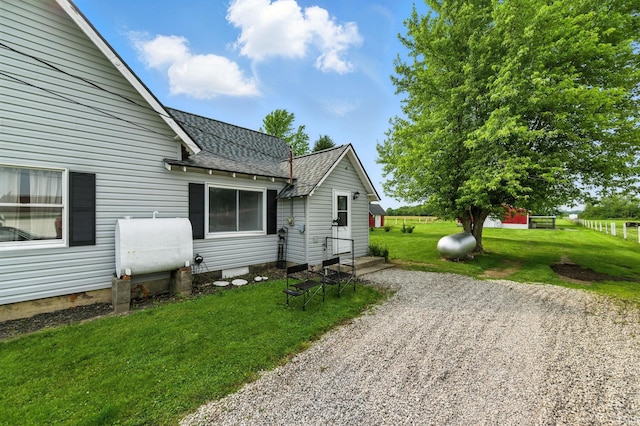 512 E Pike St, Kirklin, IN 46050 - view of side of property with a shingled roof, a lawn, and oil tank
