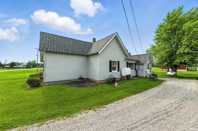 512 E Pike St, Kirklin, IN 46050 - view of property exterior featuring roof with shingles, a lawn, and gravel driveway
