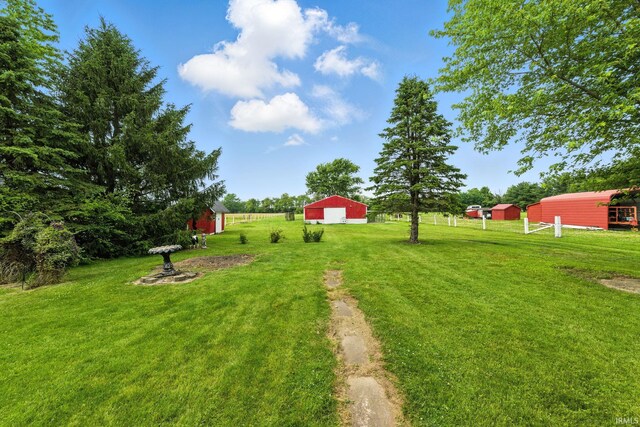 512 E Pike St, Kirklin, IN 46050 - view of green lawn with an outbuilding, a detached garage, an outdoor structure, and driveway