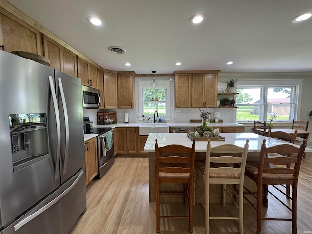 1635 Liberty St, Covington, IN 47932 - kitchen featuring appliances with stainless steel finishes, light countertops, brown cabinets, light wood finished floors, and recessed lighting