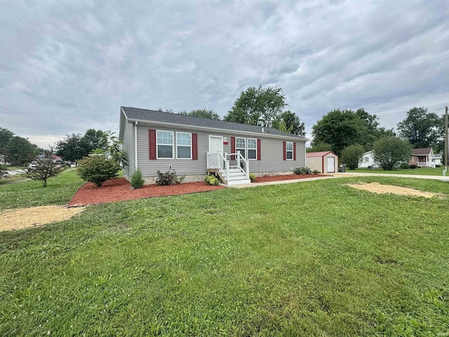 215 N Jefferson St, Lyons, IN 47443 - view of front of house with a storage shed, a front lawn, and a detached garage