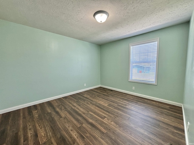 215 N Jefferson St, Lyons, IN 47443 - empty room featuring dark wood-style flooring and a textured ceiling