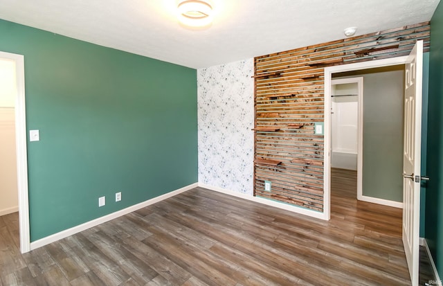 390 Mallard Cir, Chandler, IN 47610 - unfurnished room with an accent wall, wood finished floors, and wallpapered walls