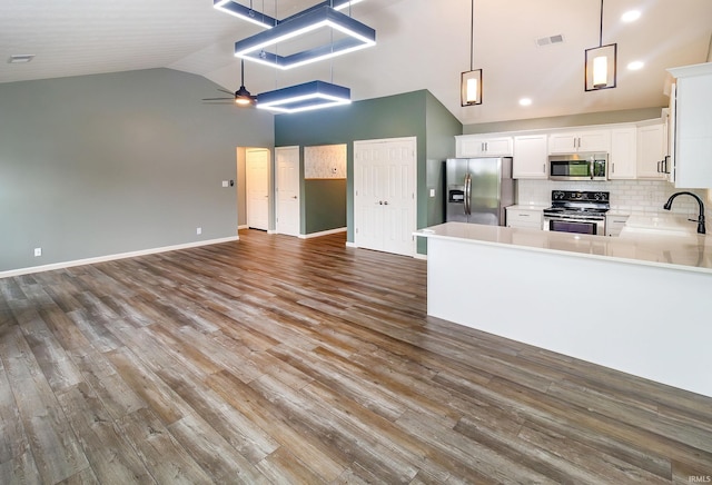390 Mallard Cir, Chandler, IN 47610 - kitchen with stainless steel appliances, high vaulted ceiling, open floor plan, white cabinetry, and ceiling fan