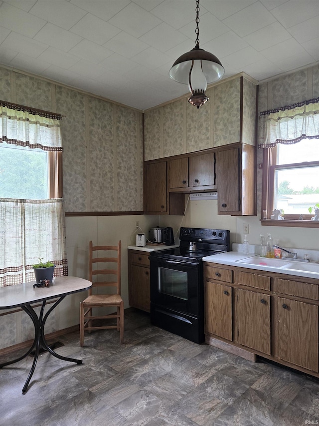 221 W 11th St, Bicknell, IN 47512 - kitchen featuring black electric range oven, plenty of natural light, light countertops, wallpapered walls, and wainscoting