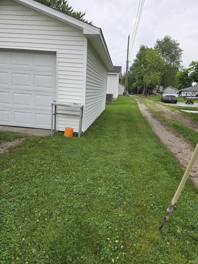 221 W 11th St, Bicknell, IN 47512 - view of side of home featuring driveway, a yard, and a garage