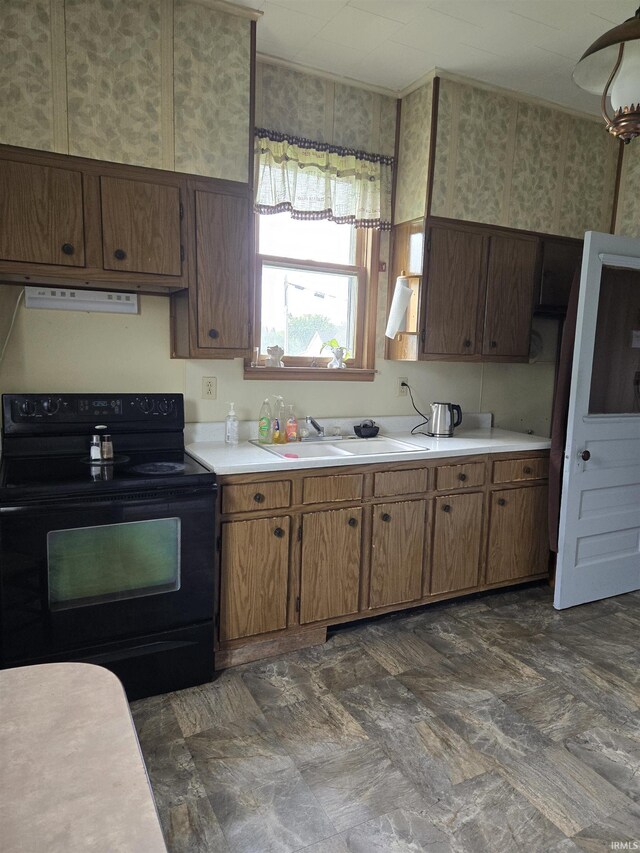 221 W 11th St, Bicknell, IN 47512 - kitchen featuring black range with electric cooktop, light countertops, extractor fan, ornamental molding, and brown cabinetry