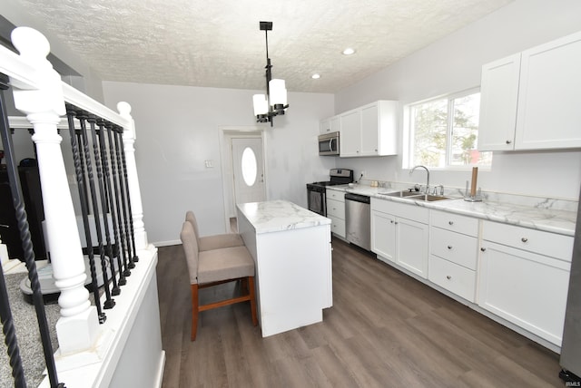 206 N Van Buren Ave, Fowler, IN 47944 - kitchen with appliances with stainless steel finishes, a textured ceiling, a kitchen island, white cabinets, and dark wood finished floors