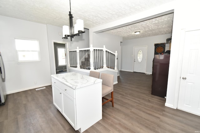 206 N Van Buren Ave, Fowler, IN 47944 - kitchen with a chandelier, white cabinets, dark wood-style floors, pendant lighting, and freestanding refrigerator