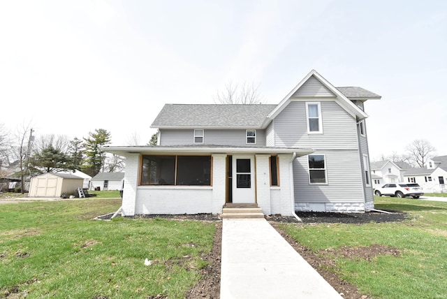 206 N Van Buren Ave, Fowler, IN 47944 - view of front of house featuring a storage unit, a front yard, roof with shingles, and brick siding