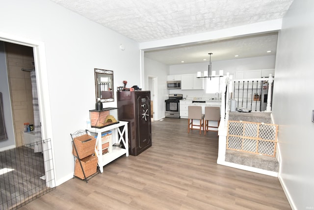 206 N Van Buren Ave, Fowler, IN 47944 - hall with a chandelier, light wood-style flooring, recessed lighting, and a textured ceiling